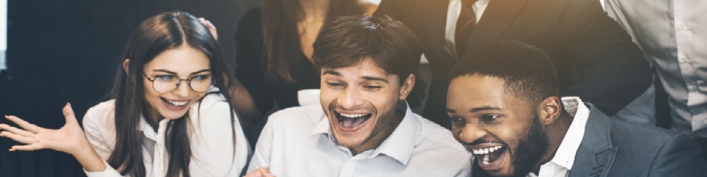Happy business people celebrating success looking at laptop